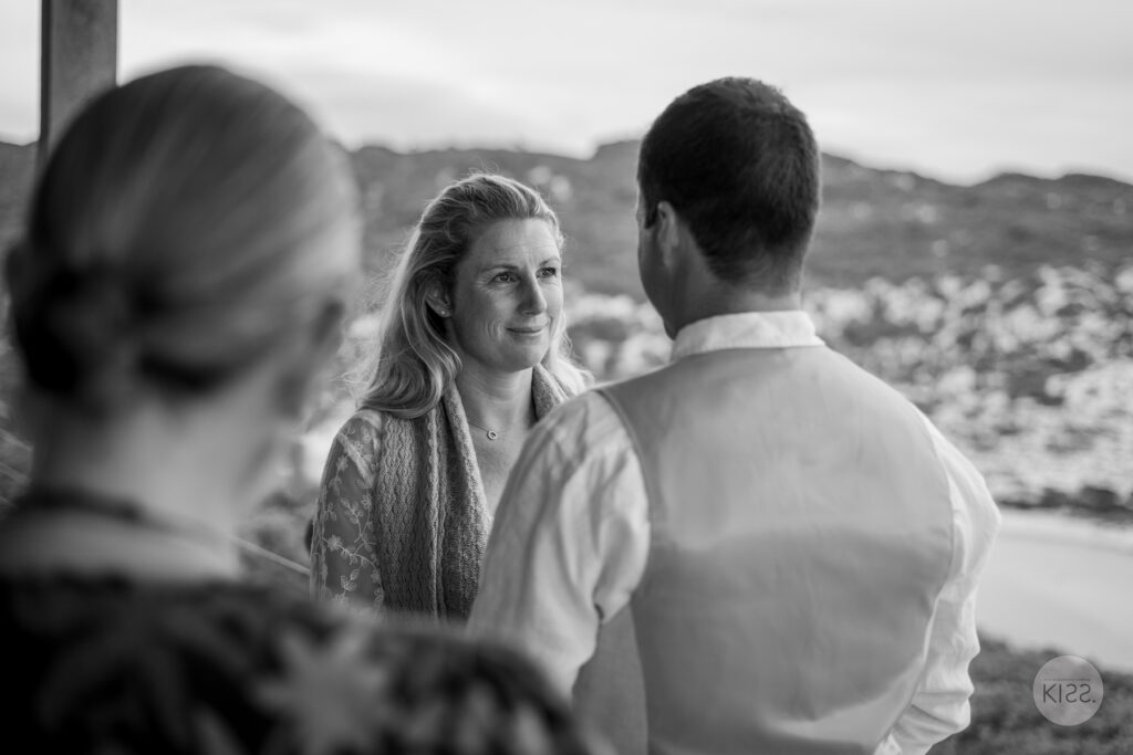 A bride smiling during the ceremony, in black and white